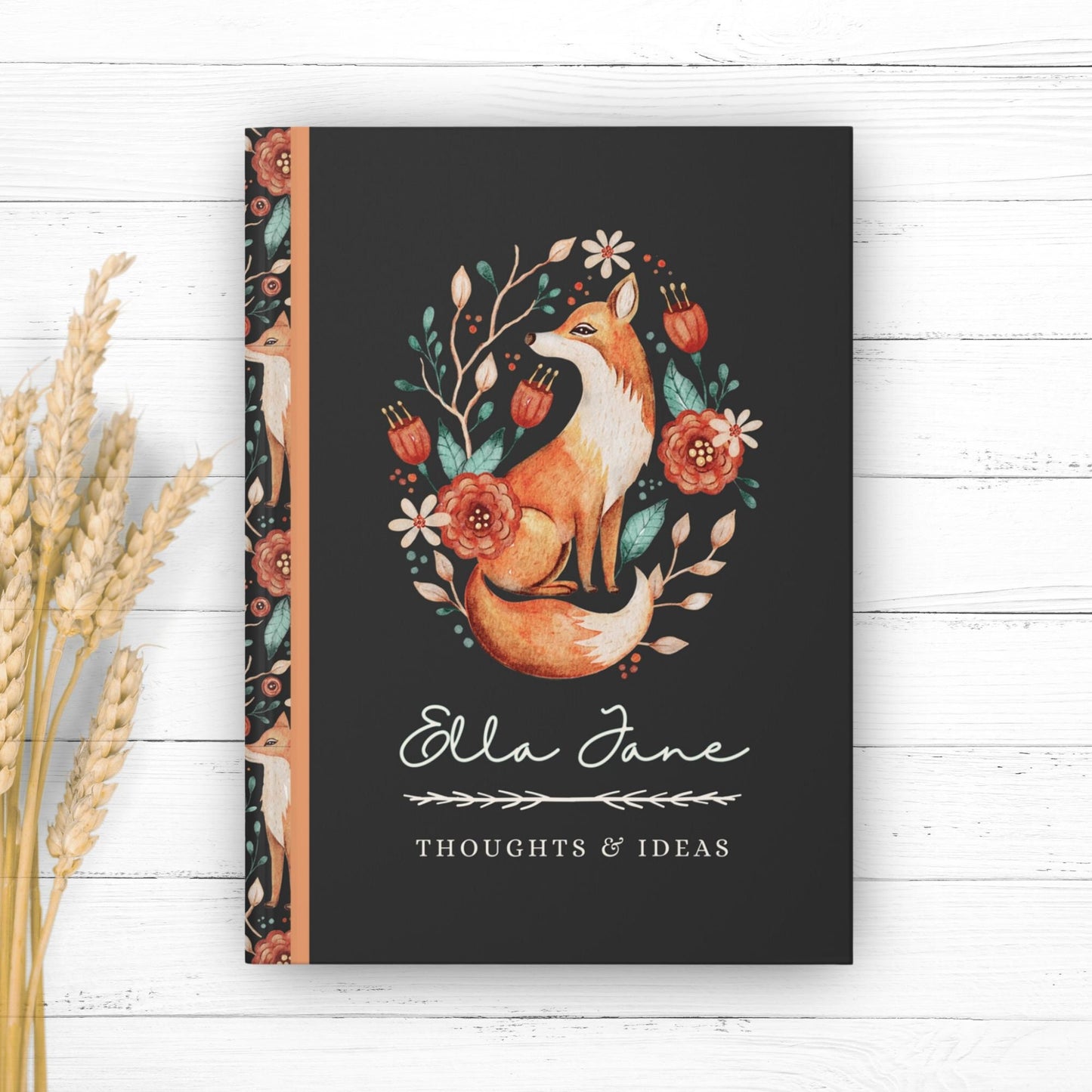 Hardcover journal with fox design on cover and fox pattern on back. Journal is personalized with the first name of recipient, and says thoughts and ideas under the name. Fox design features floral elements in a vintage illustrated style.